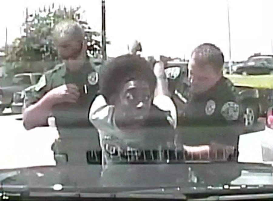 The woman shouts and resists the officers touch as she asks “Why are you doing this to me?” the officer tries getting King on the ground, as she pulls up. Image Credit: YouTube