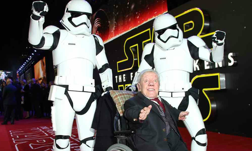 Kenny Baker, center, poses for photographers upon arrival at the European premiere of the latest Star Wars movie, The Force Awakens. Image Credit: EW